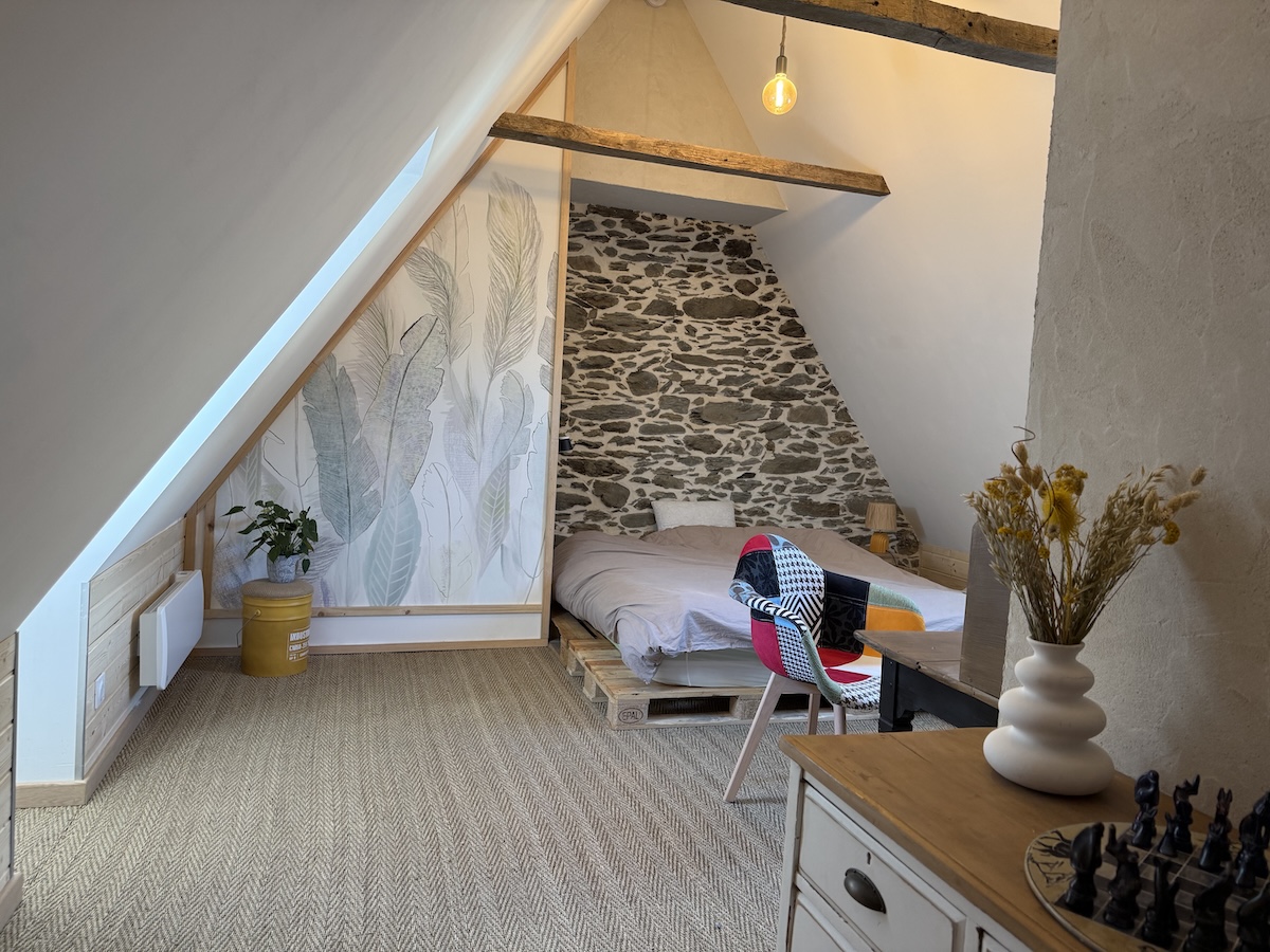 Chambre à l'étage, sous les combles, mur en pierre