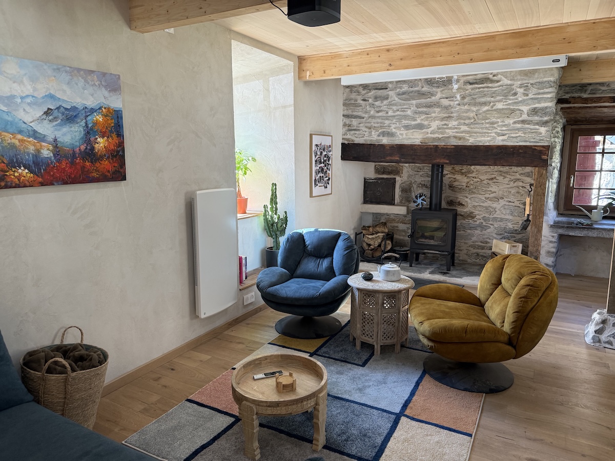 Salon avec fauteuils et poêle à bois en pierre