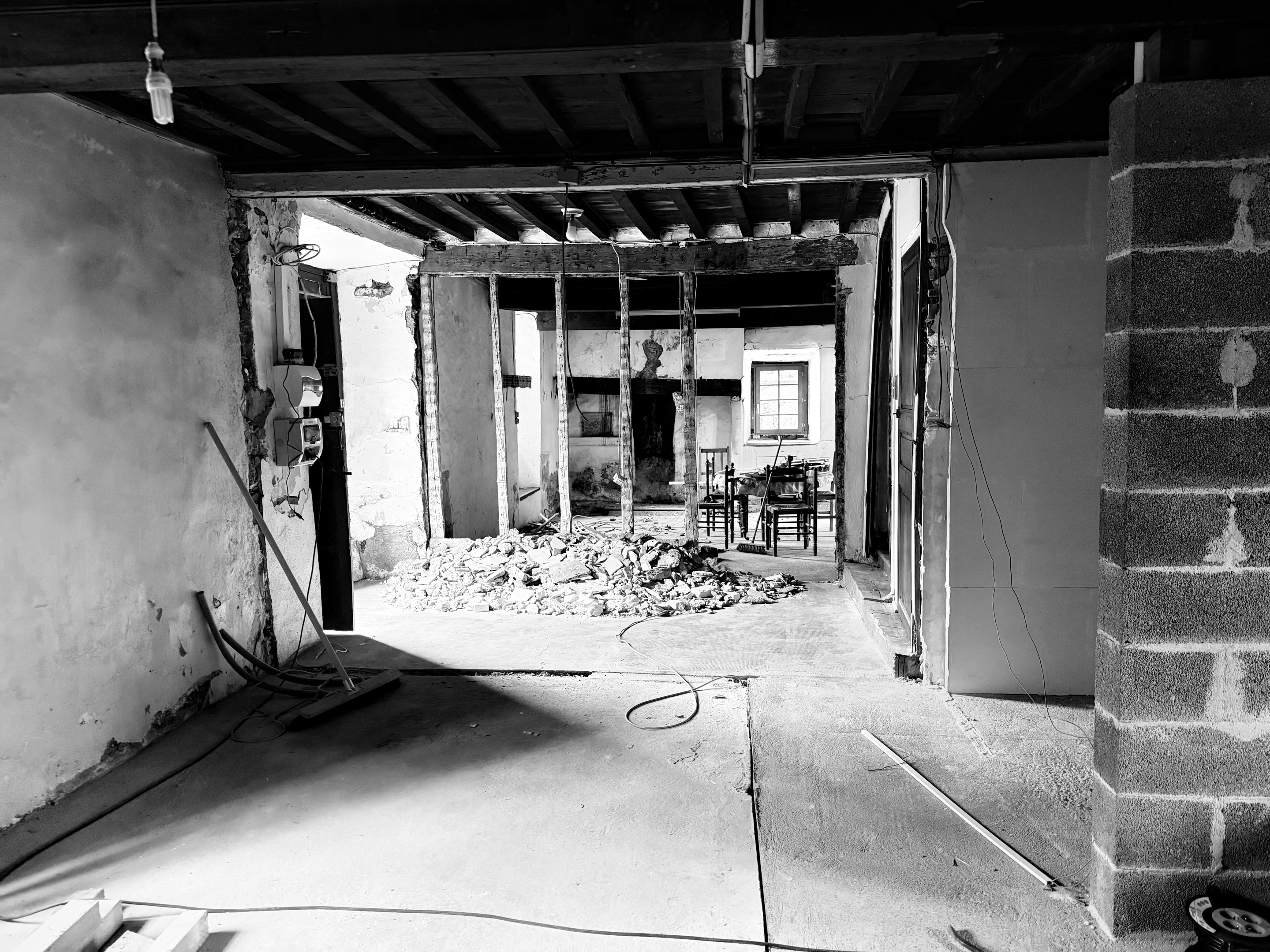 Mur ouvert pendant le chantier, gravats au sol