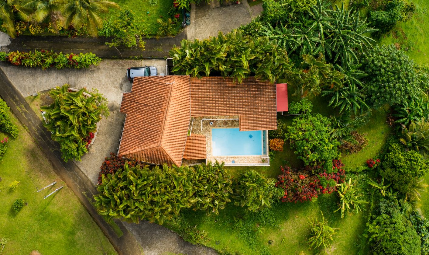 La villa et sa piscine vues du ciel, entourées de bananiers et palmiers